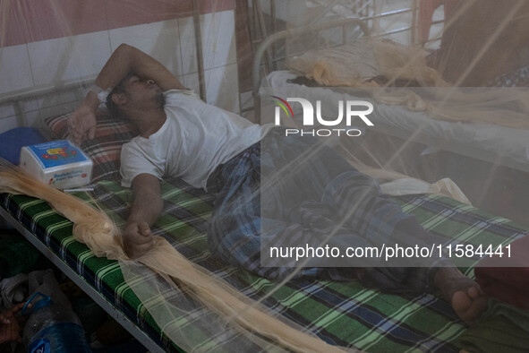 Dengue patients lie inside mosquito nets at Mugda Medical College and Hospital in Dhaka, Bangladesh, on September 18, 2024. 