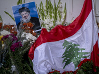 A portrait of Lebanon Hezbollah's Secretary-General Hassan Nasrallah and a Lebanese flag are pictured next to flowers placed in front of the...