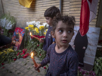 Iranian children hold candles while standing in front of the Lebanese embassy as a gesture of sympathy for victims of the deadly pager attac...