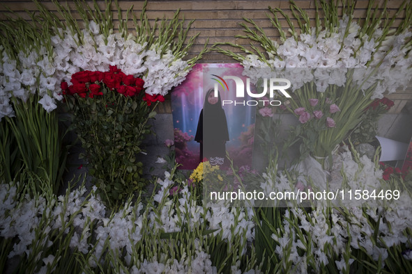 A symbolic portrait of a young Lebanese girl who was killed in a deadly pager attack is pictured next to flowers placed in front of the Leba...