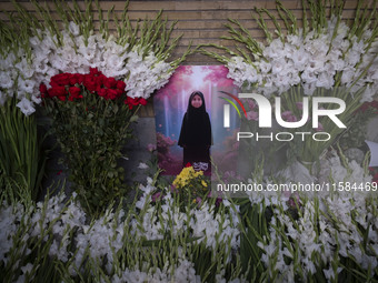 A symbolic portrait of a young Lebanese girl who was killed in a deadly pager attack is pictured next to flowers placed in front of the Leba...