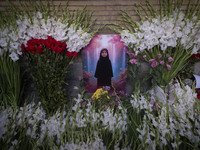 A symbolic portrait of a young Lebanese girl who was killed in a deadly pager attack is pictured next to flowers placed in front of the Leba...