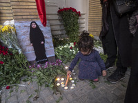 A young Iranian girl lights candles next to a portrait of a young Lebanese girl who is killed in a deadly pager attack in Lebanon, in front...