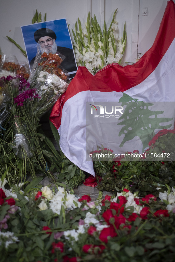 A portrait of Lebanon Hezbollah's Secretary-General Hassan Nasrallah and a Lebanese flag are pictured next to flowers placed in front of the...