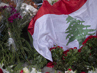 A portrait of Lebanon Hezbollah's Secretary-General Hassan Nasrallah and a Lebanese flag are pictured next to flowers placed in front of the...