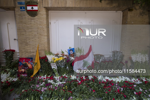 A portrait of Lebanon Hezbollah's Secretary-General Hassan Nasrallah and a Lebanese flag are pictured next to flowers placed in front of the...