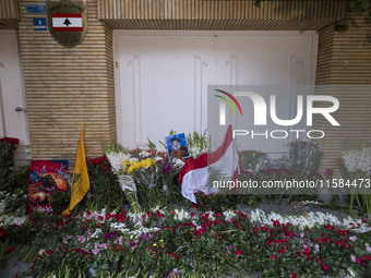 A portrait of Lebanon Hezbollah's Secretary-General Hassan Nasrallah and a Lebanese flag are pictured next to flowers placed in front of the...