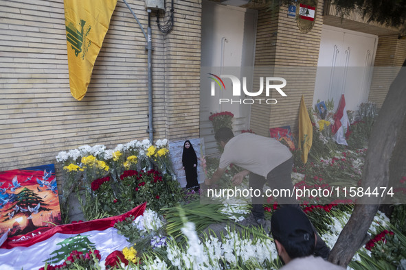 An Iranian man places flowers as sympathy for victims of the deadly pager attack in Lebanon, in front of the Lebanese embassy in northern Te...