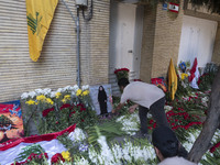 An Iranian man places flowers as sympathy for victims of the deadly pager attack in Lebanon, in front of the Lebanese embassy in northern Te...