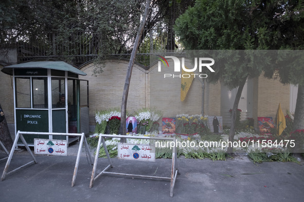 Portraits of a young Lebanese girl who was killed in a deadly pager attack, a flag of Lebanon's Hezbollah, and flowers are placed in front o...