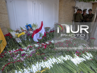 A portrait of Lebanon Hezbollah's Secretary-General Hassan Nasrallah and a Lebanese flag are pictured next to flowers placed in front of the...