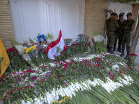 A portrait of Lebanon Hezbollah's Secretary-General Hassan Nasrallah and a Lebanese flag are pictured next to flowers placed in front of the...