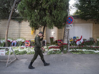 An Iranian soldier walks past flowers placed in front of the Lebanese embassy as a gesture of sympathy for victims of the deadly pager attac...