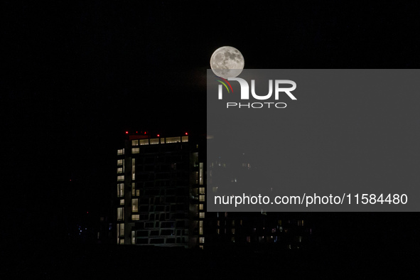 The Harvest Moon rises behind the casino, hotel, and resort, City Of Dreams, in Limassol, Cyprus, on September 18, 2024. The term ''harvest...