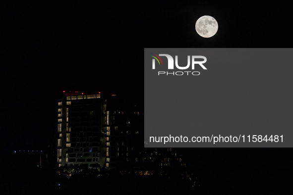 The Harvest Moon rises behind the casino, hotel, and resort, City Of Dreams, in Limassol, Cyprus, on September 18, 2024. The term ''harvest...