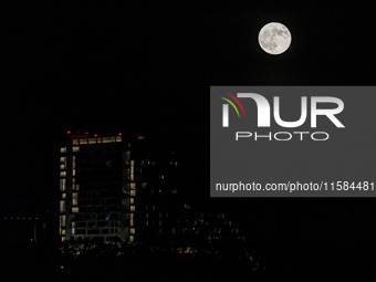 The Harvest Moon rises behind the casino, hotel, and resort, City Of Dreams, in Limassol, Cyprus, on September 18, 2024. The term ''harvest...