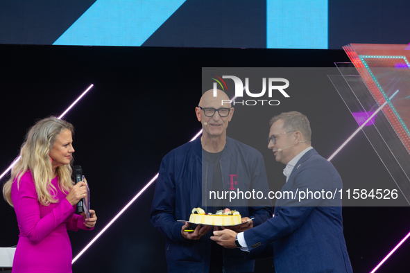 Timotheus Hoettges, CEO of Deutsche Telekom, receives a birthday cake from Barbara Schoneberger and Klaus Werner, the director of the manage...