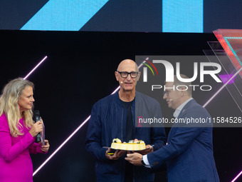 Timotheus Hoettges, CEO of Deutsche Telekom, receives a birthday cake from Barbara Schoneberger and Klaus Werner, the director of the manage...