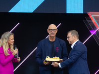 Timotheus Hoettges, CEO of Deutsche Telekom, receives a birthday cake from Barbara Schoneberger and Klaus Werner, the director of the manage...