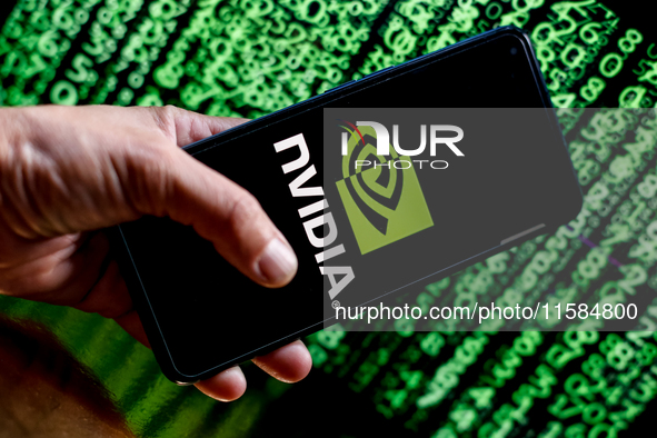 In this photo illustration, the Nvidia logo is seen displayed on a smartphone screen against a computer screen displaying a matrix image, as...