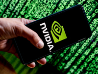 In this photo illustration, the Nvidia logo is seen displayed on a smartphone screen against a computer screen displaying a matrix image, as...