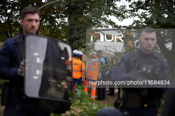 People from NGE discuss with a Gendarme as the excavator works on the destruction of the 'Verger' ZAD. For the second day, Gendarmerie and C...