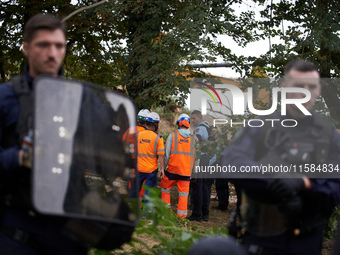 People from NGE discuss with a Gendarme as the excavator works on the destruction of the 'Verger' ZAD. For the second day, Gendarmerie and C...