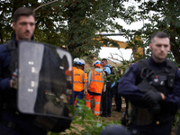 People from NGE discuss with a Gendarme as the excavator works on the destruction of the 'Verger' ZAD. For the second day, Gendarmerie and C...