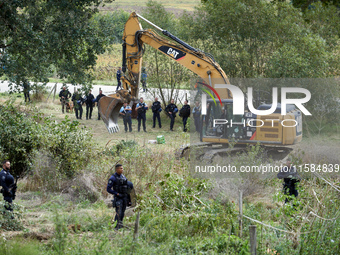 An excavator begins the work to destroy the 'Verger' ZAD as CNAMO policemen prepare to intervene to catch the people living in the tree on t...