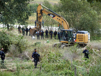 An excavator begins the work to destroy the 'Verger' ZAD as CNAMO policemen prepare to intervene to catch the people living in the tree on t...