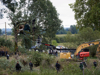 Access to the trees where the 'Ecureuil' (Squirrel) lives is blocked by policemen as workers from NGE wait to begin the destruction of the '...