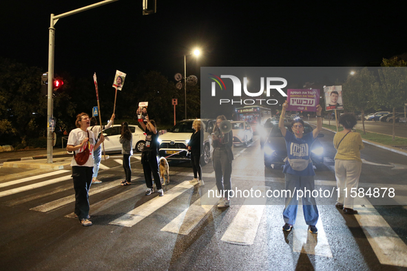 Israeli protesters block Herzog Street in West Jerusalem, near Prime Minister Netanyahu's residence, calling for an end to the war and the i...