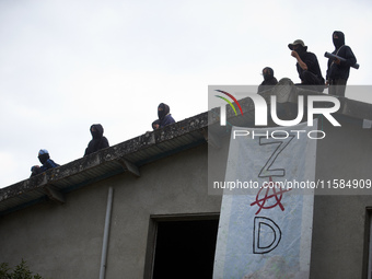 People stand on the roof of the 'Verger' house. The banner reads 'ZAD' (Zone to Defend). For the second day, Gendarmerie and CNAMO try to di...