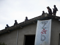 People stand on the roof of the 'Verger' house. The banner reads 'ZAD' (Zone to Defend). For the second day, Gendarmerie and CNAMO try to di...