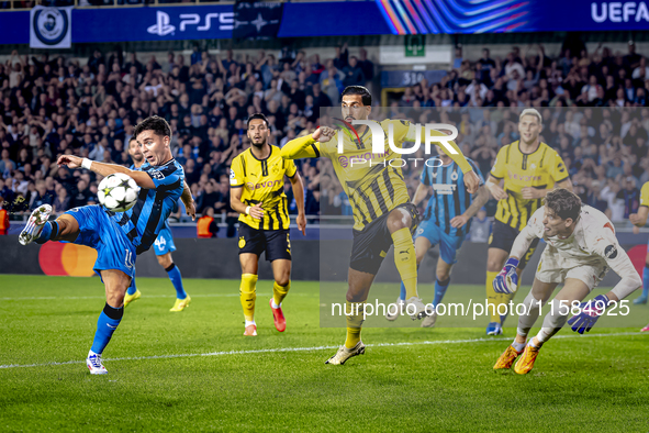 Club Brugge midfielder Hugo Vetlesen, Borussia Dortmund defender Emre Can, and Borussia Dortmund goalkeeper Gregor Kobel during the match be...