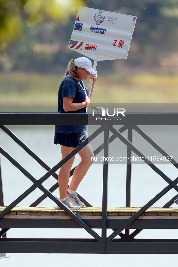 GAINESVILLE, VIRGINIA - SEPTEMBER 15: A standard bearer carries the sign on the bridge to the 12th tee for the score of Vice Captain Anna No...