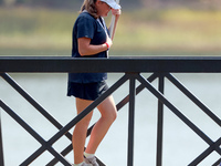 GAINESVILLE, VIRGINIA - SEPTEMBER 15: A standard bearer carries the sign on the bridge to the 12th tee for the score of Vice Captain Anna No...