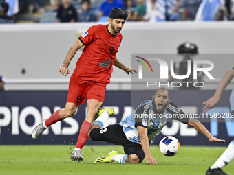 Aissa Belal Laidouni (R) of Al Wakrah SC battles for the ball with Mahdi Torabi of Tractor SC during the AFC Champions League football match...