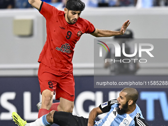 Aissa Belal Laidouni (R) of Al Wakrah SC battles for the ball with Mahdi Torabi of Tractor SC during the AFC Champions League football match...