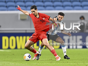 Ayoub Assal (R) of Al Wakrah SC battles for the ball with Mohammad Naderi of Tractor SC during the AFC Champions League elite football match...