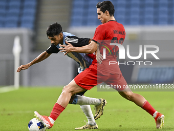 Nabil Irfan of Al Wakrah SC battles for the ball with Mohammad Naderi of Tractor SC during the AFC Champions League football match between A...