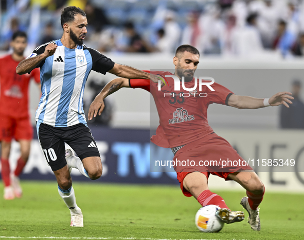 Farid Boulaya of Al Wakrah SC battles for the ball with Aref Aghasi of Tractor SC during the AFC Champions League football match between Al...