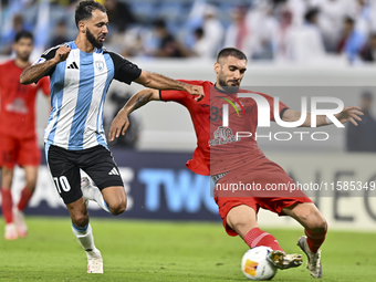 Farid Boulaya of Al Wakrah SC battles for the ball with Aref Aghasi of Tractor SC during the AFC Champions League football match between Al...