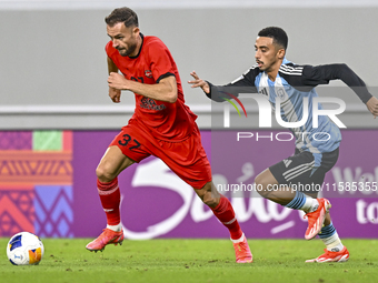 Khaled Mohammed M Saleh of Al Wakrah SC battles for the ball with Sokol Cikalleshi of Tractor SC during the AFC Champions League football ma...