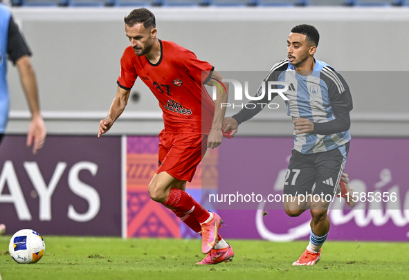 Khaled Mohammed M Saleh of Al Wakrah SC battles for the ball with Sokol Cikalleshi of Tractor SC during the AFC Champions League football ma...