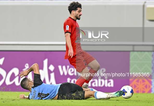 Tameem Almuhaza (bottom) of Al Wakrah SC battles for the ball with Mahdi Hashemnezhad of Tractor SC during the AFC Champions League football...