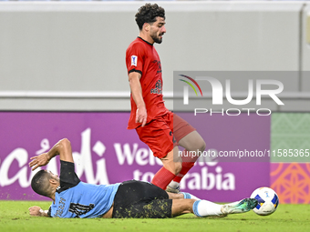 Tameem Almuhaza (bottom) of Al Wakrah SC battles for the ball with Mahdi Hashemnezhad of Tractor SC during the AFC Champions League football...