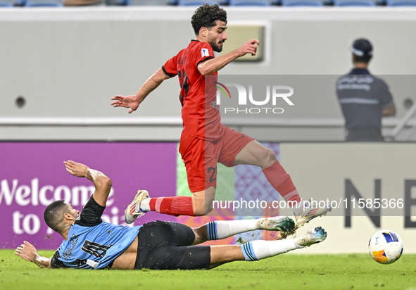 Tameem Almuhaza (bottom) of Al Wakrah SC battles for the ball with Mahdi Hashemnezhad of Tractor SC during the AFC Champions League football...