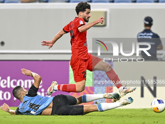 Tameem Almuhaza (bottom) of Al Wakrah SC battles for the ball with Mahdi Hashemnezhad of Tractor SC during the AFC Champions League football...