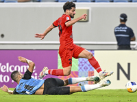 Tameem Almuhaza (bottom) of Al Wakrah SC battles for the ball with Mahdi Hashemnezhad of Tractor SC during the AFC Champions League football...